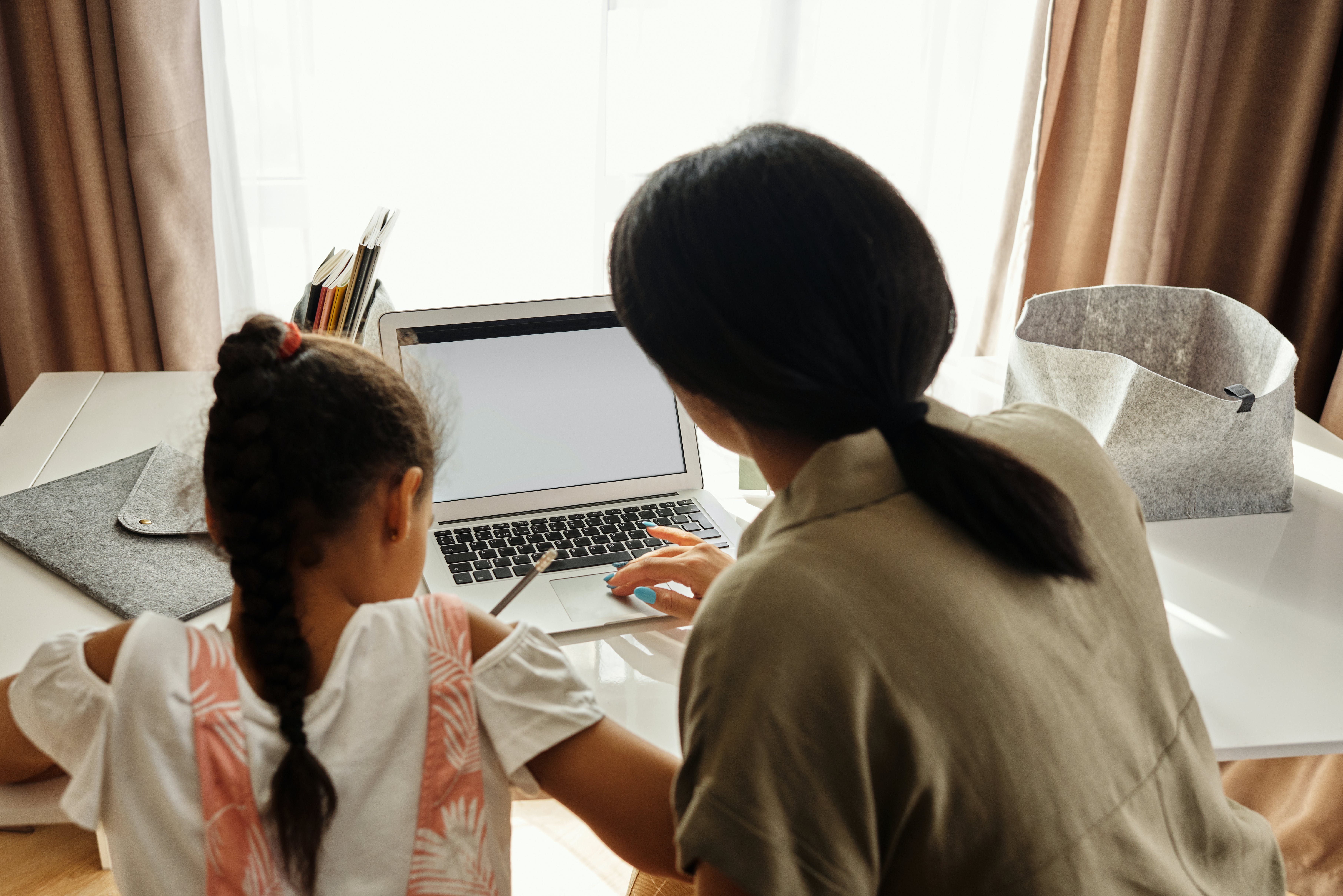 Adult showing a child information on a computer